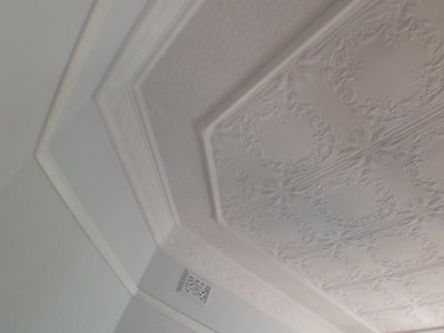 Painting historic moulded ceilings in flat white hides minor damage. 